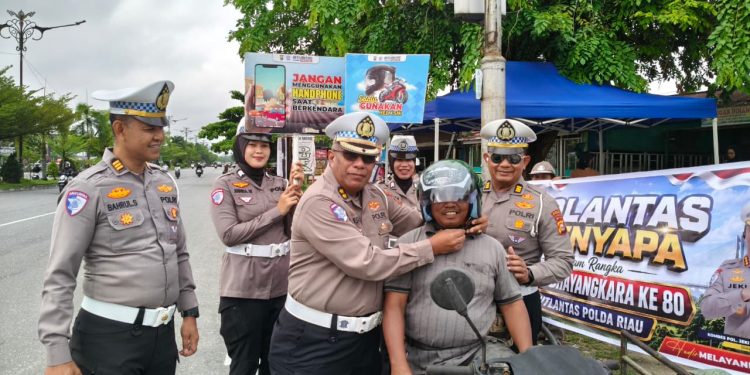 Saat Polantas Menyapa di Persimpangan Jalan, Puluhan Helm SNI di Bagikan dan ajak Pengendara Patuhi Tata Tertb Berlalu Lintas