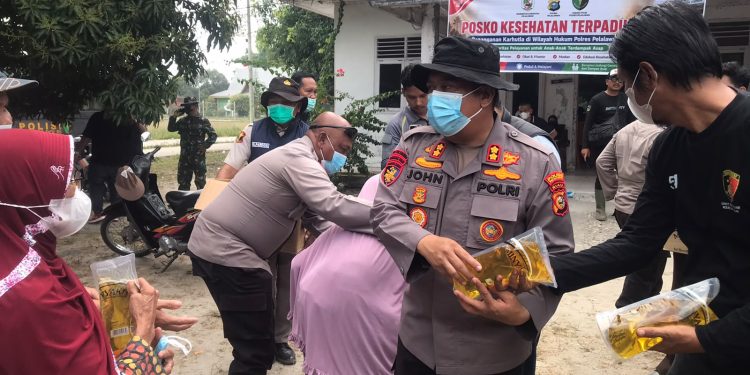 Kapolres Pelalawan Bersama Tim Gabungan Bagikan Masker dan Sembako untuk Warga Terdampak Asap Karhutla di Kerumutan