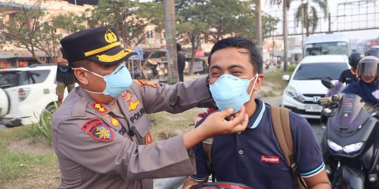 DITENGAH KABUT ASAP KAPOLRES PELALAWAN TURUN KE JALAN BAGI MASKER GRATIS UNTUK PENGENDARA DAN WARGA